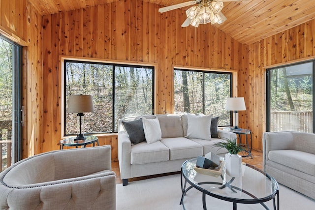living room featuring wood walls, lofted ceiling, and a healthy amount of sunlight