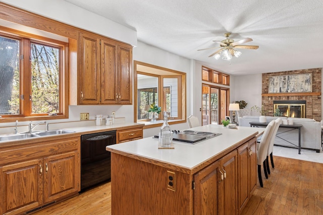 kitchen featuring a sink, a center island, plenty of natural light, and black dishwasher