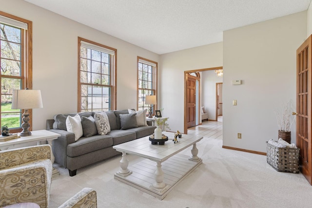 living room with a textured ceiling, a notable chandelier, light carpet, and baseboards