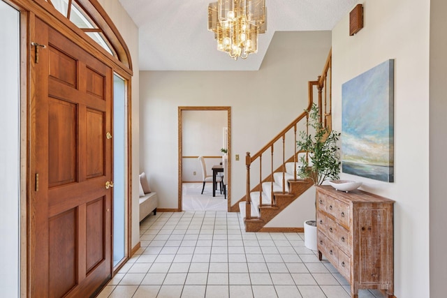 foyer with stairs, baseboards, an inviting chandelier, and light tile patterned floors