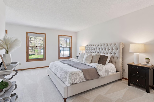 bedroom with a textured ceiling, baseboards, and light carpet