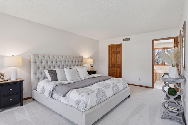 bedroom featuring visible vents, baseboards, ensuite bathroom, light colored carpet, and a textured ceiling