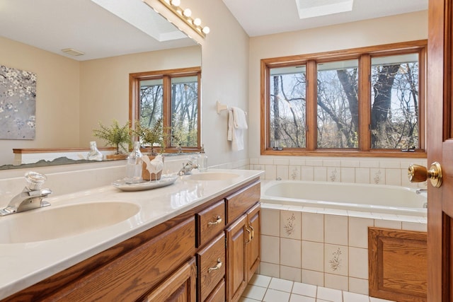 full bathroom with tile patterned flooring, a sink, a bath, and double vanity