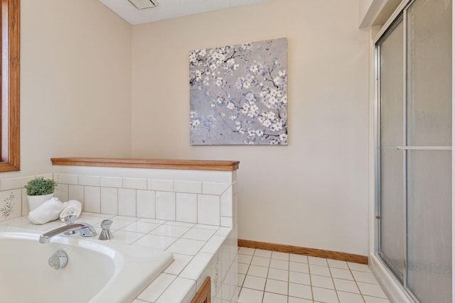 bathroom with a sink, tile patterned flooring, baseboards, a bath, and a stall shower