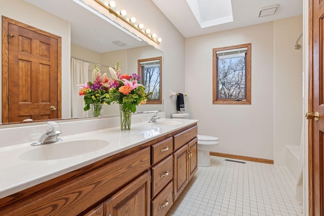 full bath featuring a sink, a skylight, a shower with shower curtain, and visible vents