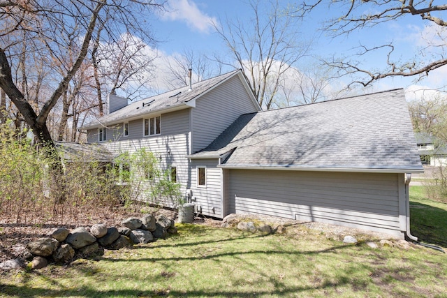 view of property exterior featuring a shingled roof, a yard, and a chimney