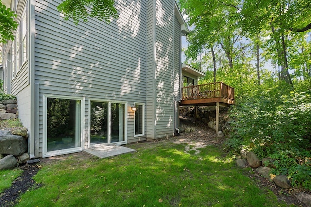 rear view of house featuring a yard and a deck