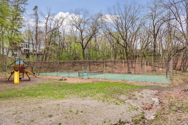 view of yard with fence, a tennis court, and playground community
