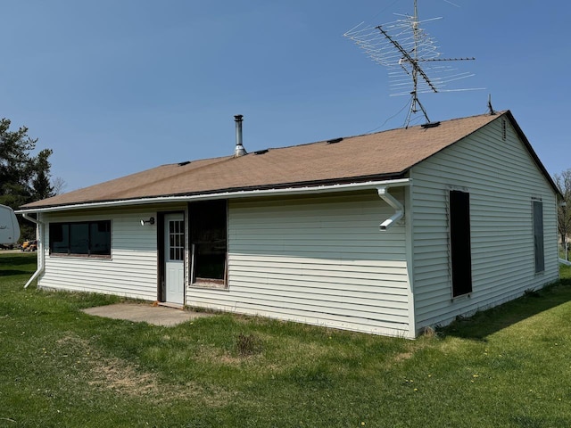 rear view of property featuring a lawn