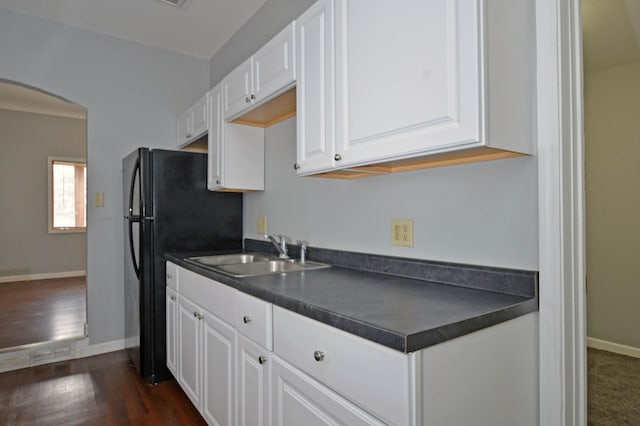 kitchen featuring black refrigerator, dark wood-type flooring, sink, and white cabinetry