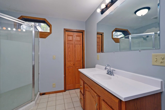 bathroom with a wealth of natural light, tile patterned floors, an enclosed shower, and vanity