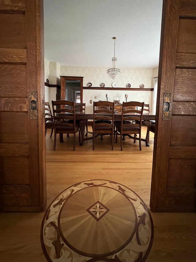 dining space with a textured ceiling and hardwood / wood-style floors