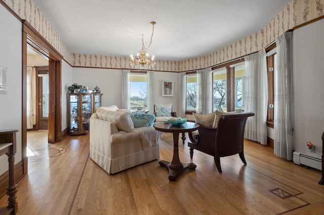 living room featuring a notable chandelier, light hardwood / wood-style flooring, and baseboard heating