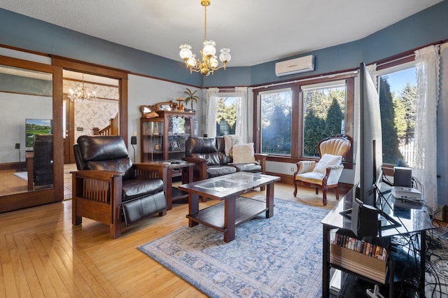 living room featuring light wood-type flooring, an AC wall unit, and an inviting chandelier