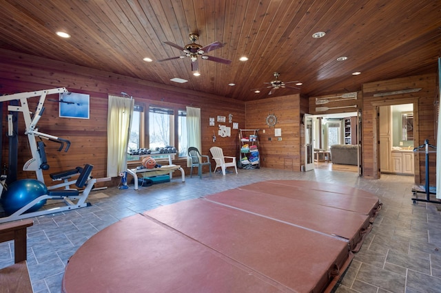 interior space with wooden ceiling, plenty of natural light, ceiling fan, and wooden walls