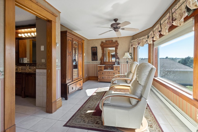 sunroom / solarium with plenty of natural light, a baseboard heating unit, and ceiling fan