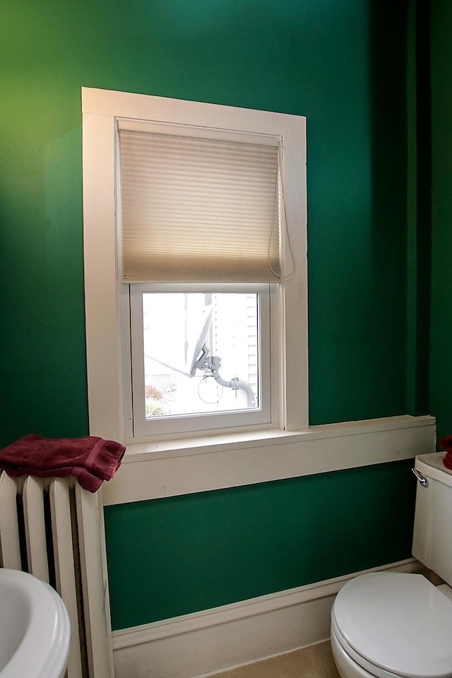 bathroom featuring radiator and toilet