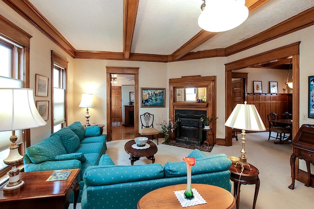 carpeted living room featuring crown molding, beamed ceiling, and a fireplace