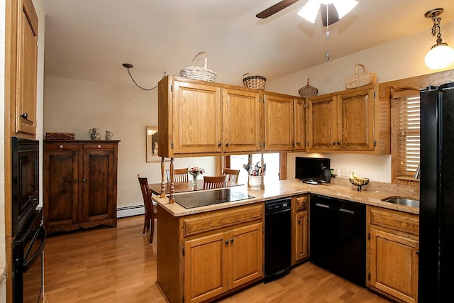 kitchen with light hardwood / wood-style floors, black appliances, decorative light fixtures, and kitchen peninsula