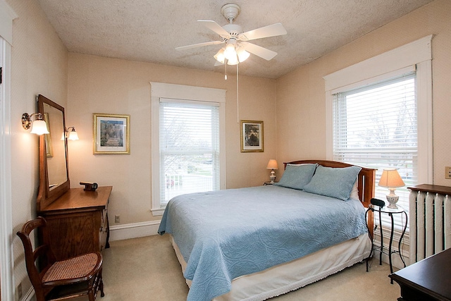 carpeted bedroom with a textured ceiling and ceiling fan