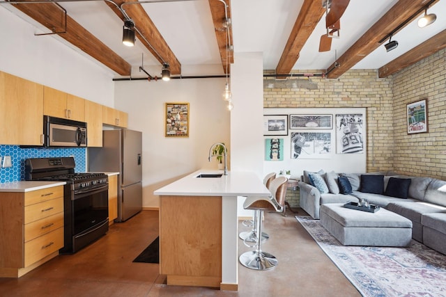 kitchen featuring decorative backsplash, appliances with stainless steel finishes, a breakfast bar, beamed ceiling, and brick wall