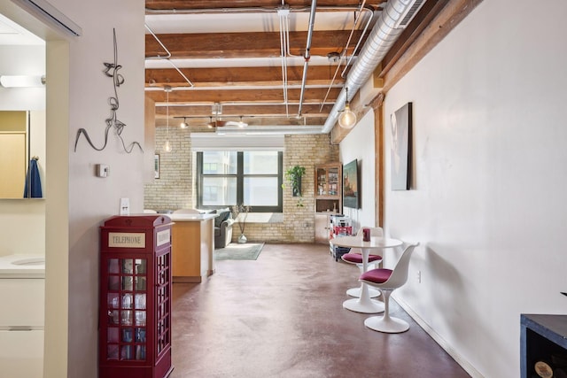 misc room featuring concrete flooring and brick wall