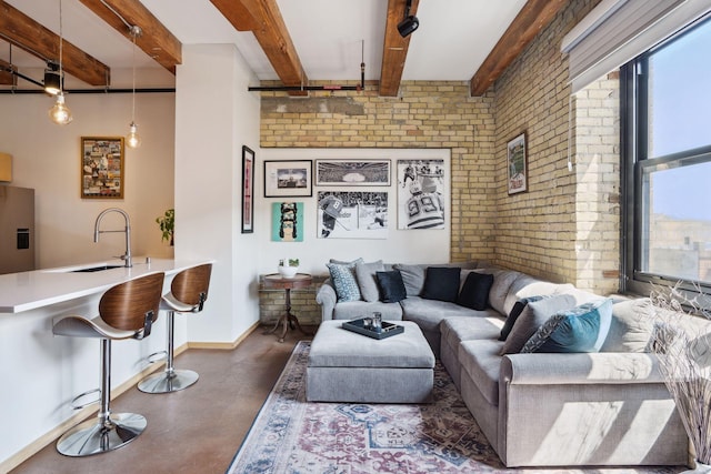 living room with beamed ceiling, brick wall, and sink