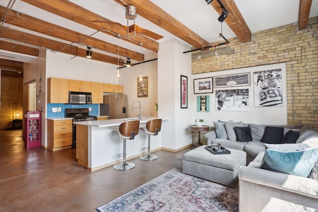 living room with beamed ceiling, brick wall, and sink