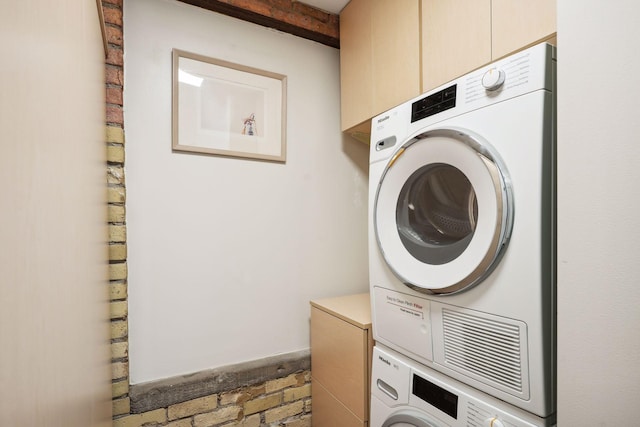 clothes washing area with stacked washer and clothes dryer