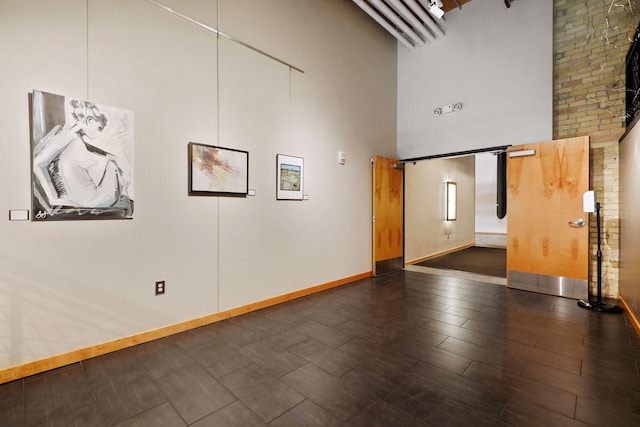 spare room with dark wood-type flooring and a high ceiling