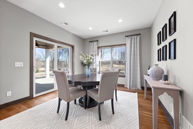 dining area with a textured ceiling and light wood-type flooring