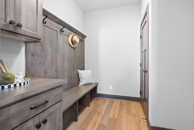 mudroom featuring light hardwood / wood-style flooring and a textured ceiling