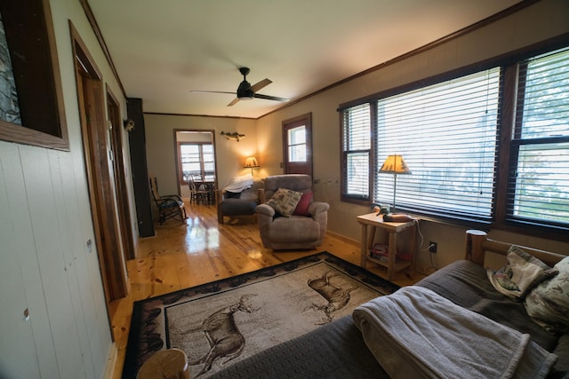 living room with ceiling fan, hardwood / wood-style flooring, and ornamental molding