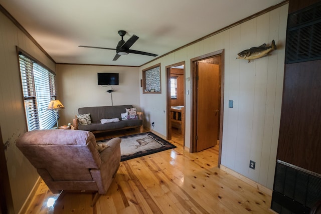 living room with crown molding, ceiling fan, and light hardwood / wood-style floors