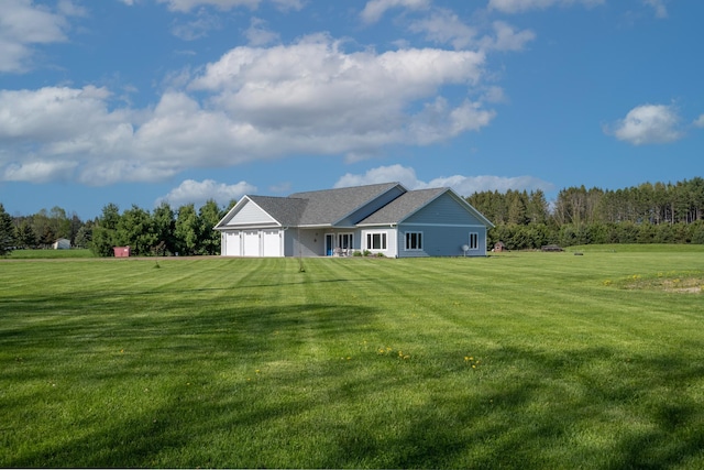 back of property with a garage and a lawn