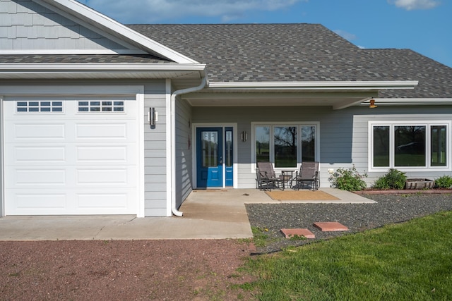 doorway to property with covered porch and a garage