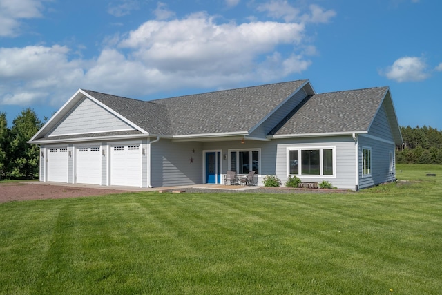 view of front of property featuring driveway, roof with shingles, an attached garage, and a front yard