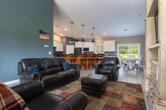 living room featuring dark wood-type flooring, recessed lighting, high vaulted ceiling, and baseboards