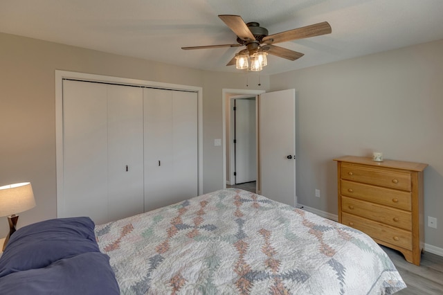 bedroom with ceiling fan, light hardwood / wood-style floors, and a closet