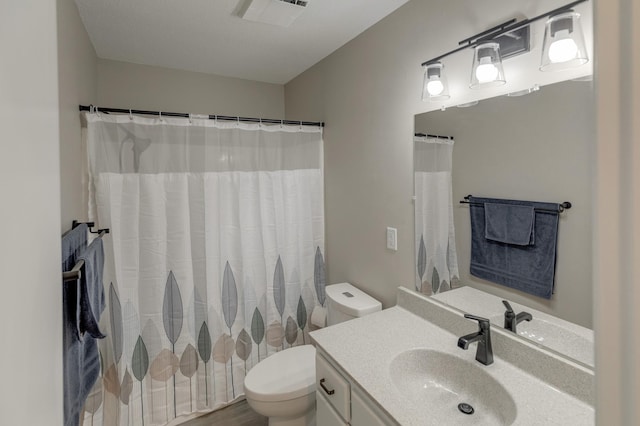 bathroom featuring toilet, a shower with shower curtain, and vanity