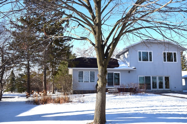 view of snow covered back of property