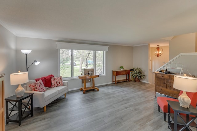 sitting room with wood-type flooring, an inviting chandelier, and ornamental molding