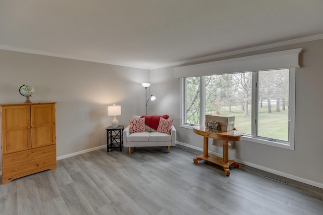 sitting room featuring light wood-type flooring and crown molding