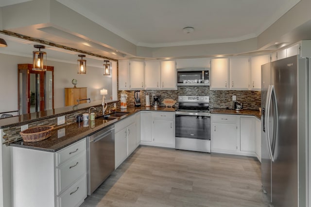 kitchen featuring stainless steel appliances, dark stone counters, sink, light hardwood / wood-style flooring, and white cabinetry