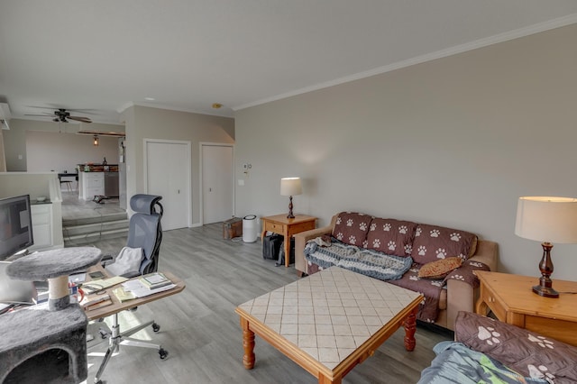 living room with ceiling fan, crown molding, and light hardwood / wood-style flooring