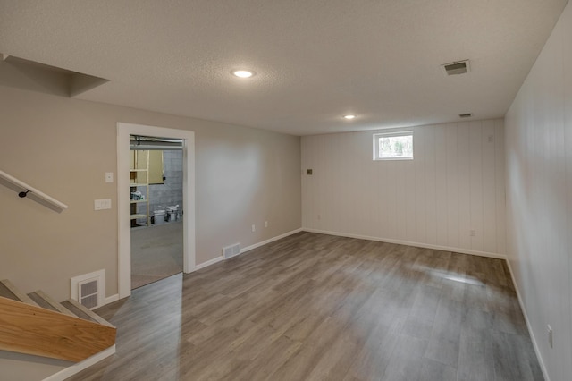 empty room with a textured ceiling and hardwood / wood-style flooring