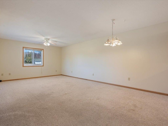 carpeted empty room featuring a chandelier