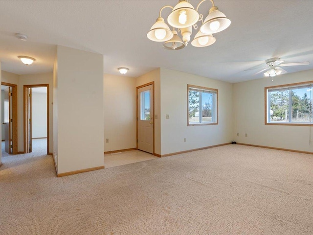 spare room featuring light carpet and ceiling fan with notable chandelier