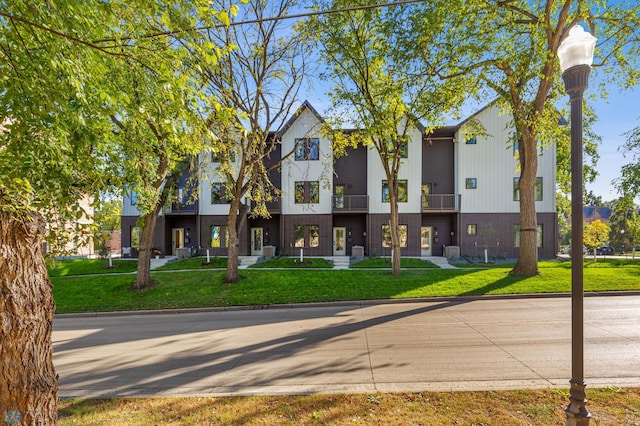 view of front of property with a balcony and a front lawn