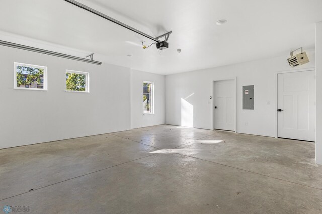 garage with a garage door opener and electric panel